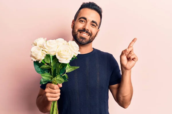 Jovem Hispânico Segurando Flores Sorrindo Feliz Apontando Com Mão Dedo — Fotografia de Stock