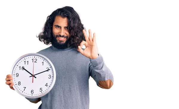 Hombre Árabe Joven Sosteniendo Gran Reloj Haciendo Signo Con Los —  Fotos de Stock