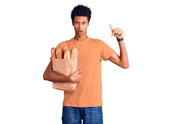 Νεαρός Αφροαμερικάνος Κρατάει Χάρτινη Σακούλα Ψωμί Που Δείχνει Προς Κάτω — Φωτογραφία Αρχείου