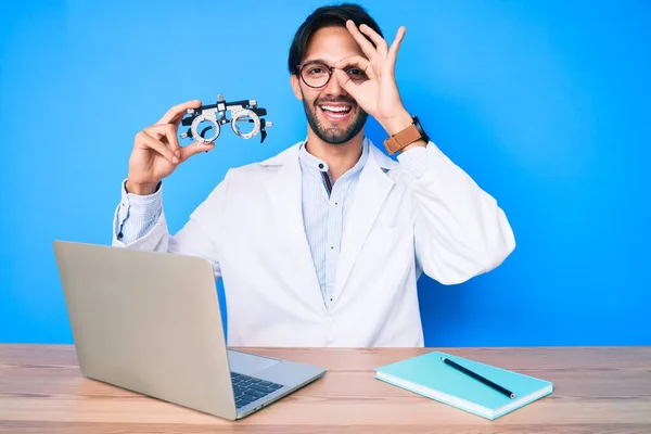 Hombre Guapo Óptico Hispano Clínica Sosteniendo Gafas Optometría Sonriendo Feliz —  Fotos de Stock