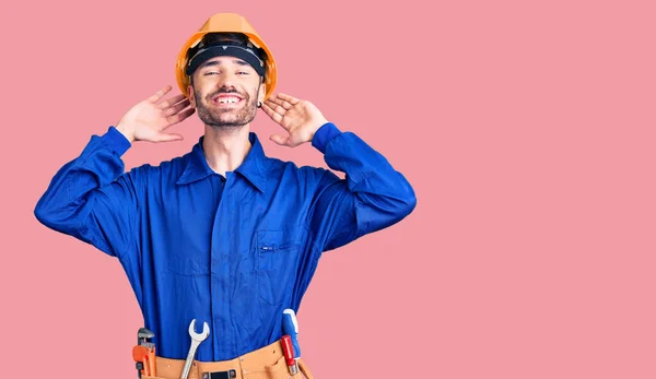 Jovem Hispânico Vestindo Uniforme Trabalhador Relaxante Alongamento Braços Mãos Atrás — Fotografia de Stock