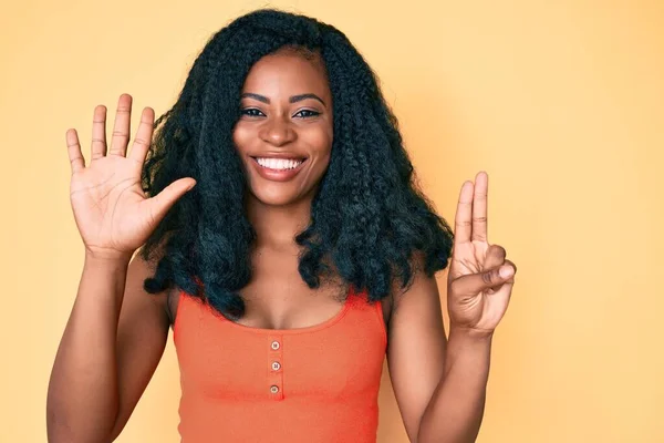 自信と幸せ笑みを浮かべている間 美しいアフリカの女性は カジュアルな服を着て指の番号7で示すと指摘 — ストック写真