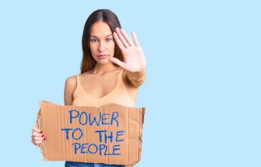 Güzel, esmer, genç bir kadın halka güç veriyor. Açık bir el ile afiş asıyor. Ciddi ve kendinden emin bir ifadeyle dur işareti yapıyor. 