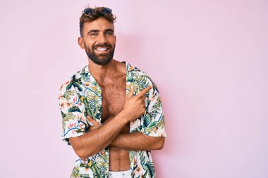 Gündelik yaz kıyafetleri giyen genç İspanyol adam zaferi mutlu bir gülümsemeyle ve kazanan yüz ifadesiyle kutluyor. 