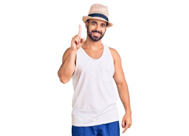 Gündelik yaz şapkası takan genç İspanyol bir numarayı gösterip işaret ederken kendinden emin ve mutlu bir şekilde gülümsüyor.. 