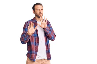 Genç, yakışıklı bir adam sıradan kıyafetler giyiyor. Avuçlarını hareket ettiriyor. Korkmuş ve iğrenç bir ifadeyle reddediyor. Dur ve yasakla. 