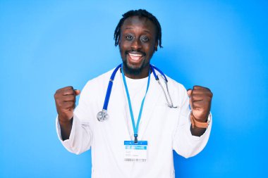 Saç örgülü, doktor steteskobu takan ve kimlik kartı takan genç Afrikalı Amerikalı gururla bağırıyor, zaferi ve başarıyı kutluyor. 