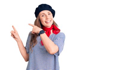 Fransız bereli ve çizgili tişörtlü güzel sarışın kadın gülümsüyor ve kameraya bakıyor.. 