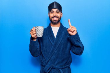 Uyku maskesi takan ve kaftan giyen genç İspanyol bir adam bir fikir veya soruyla gülümseyerek kahvemi yudumluyor. 