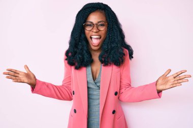 İş ceketi ve gözlük takan güzel Afrikalı kadın çılgın ve başarıyı kollarını kaldırıp heyecanla haykırarak kutluyor. Kazanan konsept 