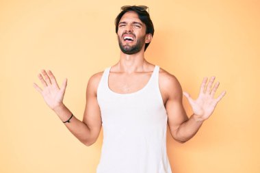 Yaz bakışı ve güneş gözlüğü takan yakışıklı İspanyol adam korku ifadesinden korkuyor ve dehşete düşüyor. El hareketlerini bırak, şok içinde bağır. panik konsepti. 