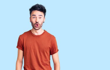 Gündelik giysiler giyen genç İspanyol adam şaşırmak için ağzı açık kalmış, korkmuş ve hayrete düşmüş, inançsız yüz. 