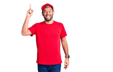 Tişört giyen ve şapkalı yakışıklı sarışın genç adam başarılı bir fikirle işaret ediyor. Heyecanlı ve mutlu. Bir numara.. 