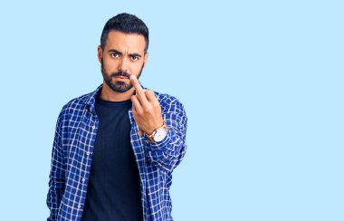 Young hispanic man wearing casual clothes showing middle finger, impolite and rude fuck off expression 