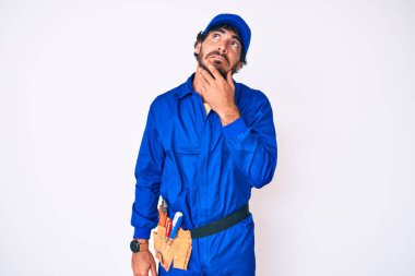 Kıvırcık saçlı ve ayı gibi giyinen yakışıklı genç adam bir soru hakkında endişeleniyor, endişeli ve gergin. 