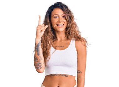 Gündelik giysiler giyen İspanyol bir kadın başarılı bir fikri işaret ediyor. Heyecanlı ve mutlu. Bir numara.. 