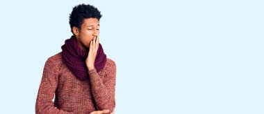 Genç Afro-Amerikan adam günlük kışlık süveter ve eşarp giymekten sıkıldı. Ağzı eliyle kapatmaktan yoruldu. Huzursuz ve uykulu.. 