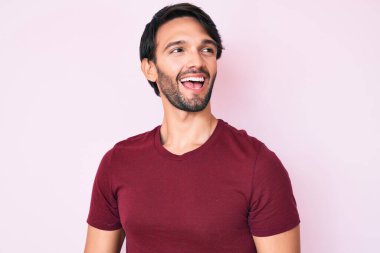 Yakışıklı, sıradan kıyafetler giyen, rahat bir görünüm takınan, doğal yüzlü ve kendinden emin bir gülümseme takınan İspanyol bir adam.. 