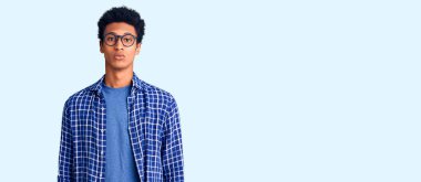 Sıradan kıyafetler ve gözlük takan genç Afro-Amerikan adam yüzünde ciddi bir ifadeyle rahatladı. Basit ve doğal bir şekilde kameraya bakıyorsun.. 