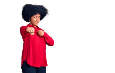 Genç Afro-Amerikalı kız gündelik kıyafetler giyip dövüşmek için yumruk atıyor, agresif ve öfkeli saldırı, tehdit ve şiddet uyguluyor. 