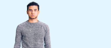 Sıradan süveter giyen, komik yüzlü, yanak şişiren Latin asıllı yakışıklı genç adam. Havayla şişmiş ağız, çılgın bir ifade.. 