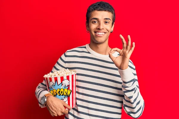 Joven Hombre Amerciano Africano Sosteniendo Palomitas Maíz Haciendo Signo Con —  Fotos de Stock