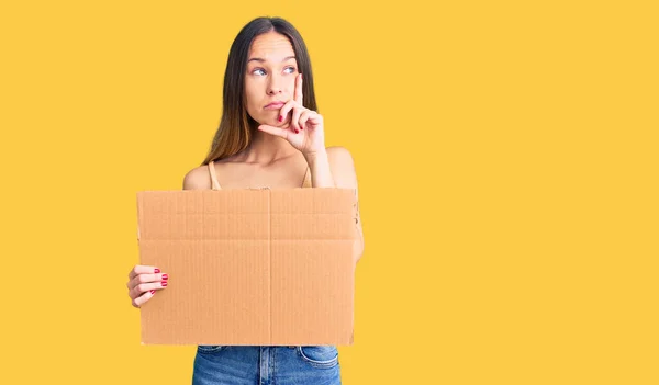 Schöne Brünette Junge Frau Mit Pappbanner Mit Leerraum Ernstes Gesicht — Stockfoto