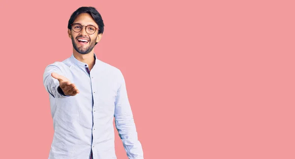 ビジネスシャツや眼鏡を着たハンサムなヒスパニック系の男性が挨拶や歓迎として握手を提供笑顔 成功したビジネス — ストック写真