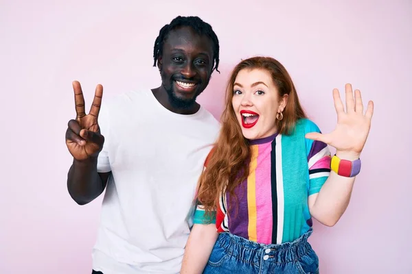 Interracial Couple Wearing Casual Clothes Showing Pointing Fingers Number Seven — Stock Photo, Image