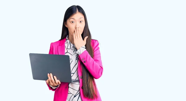 年轻美丽的中国女人用手提电脑捂着嘴 惊恐万分 惊讶的表情 — 图库照片