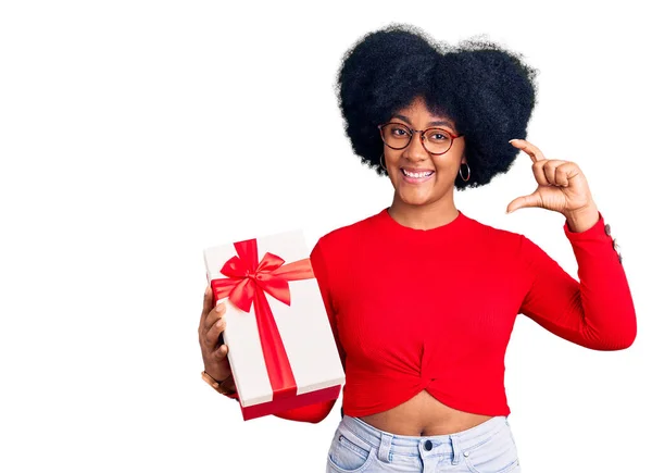 Joven Afroamericana Chica Sosteniendo Regalo Sonriente Seguro Gesto Con Mano — Foto de Stock