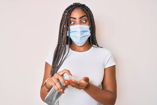 Νεαρή Αφροαμερικανή Γυναίκα Κοτσίδες Που Φοράει Ιατρική Μάσκα Χρησιμοποιώντας Απολυμαντικό — Φωτογραφία Αρχείου