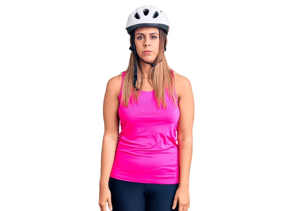 年轻漂亮的女人戴着自行车头盔 脸上带着严肃的表情 简单而自然地看着相机 — 图库照片