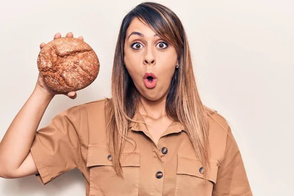 Jovem Bela Mulher Segurando Pão Assustado Surpreso Com Boca Aberta — Fotografia de Stock