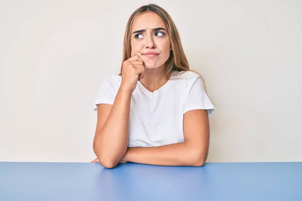 Jovem Mulher Loira Bonita Vestindo Roupas Casuais Sentado Mesa Pensando — Fotografia de Stock