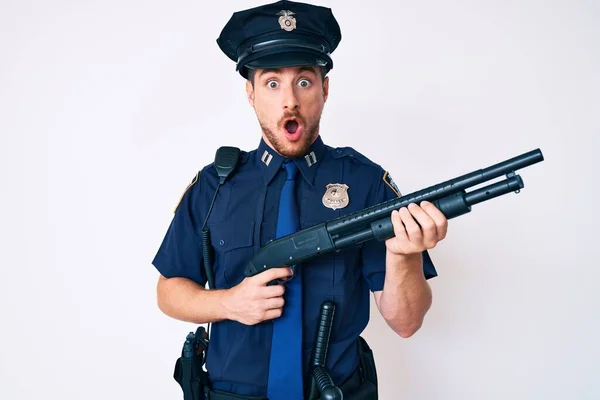 Joven Hombre Caucásico Vistiendo Uniforme Policía Sosteniendo Escopeta Asustado Sorprendido —  Fotos de Stock