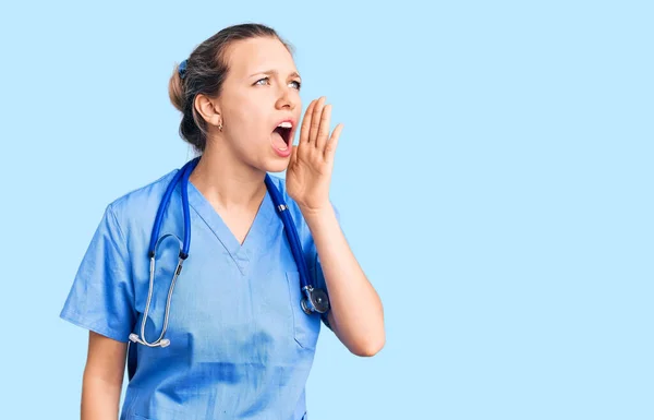 Jovem Mulher Loira Bonita Vestindo Uniforme Médico Estetoscópio Gritando Gritando — Fotografia de Stock