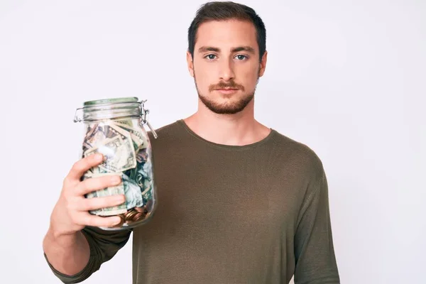 Joven Hombre Guapo Sosteniendo Tarro Con Actitud Pensamiento Ahorro Expresión —  Fotos de Stock