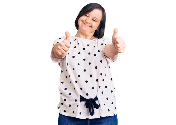 布鲁内特患有唐氏综合症的女人穿着休闲装 赞成用手做积极的手势 微笑着竖起大拇指 为成功感到高兴 优胜手势 — 图库照片