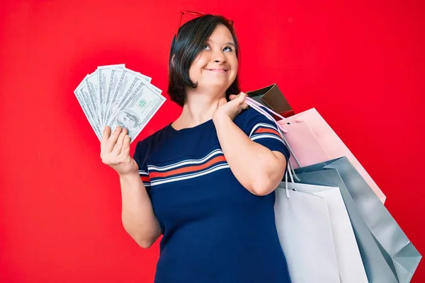 Mulher Morena Com Síndrome Segurando Sacos Compras Dólares Sorrindo Olhando — Fotografia de Stock