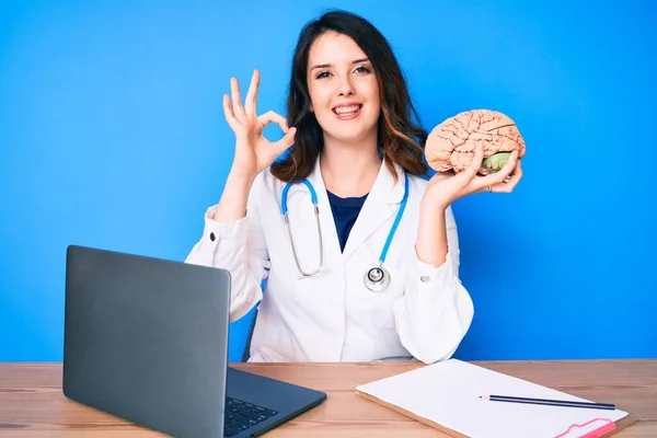 Joven Hermosa Morena Con Abrigo Médico Sosteniendo Cerebro Oficina Haciendo — Foto de Stock