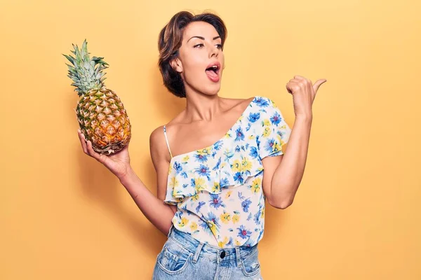 Jeune Belle Femme Tenant Ananas Pointant Pouce Vers Côté Souriant — Photo