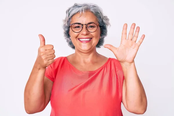 Starsza Latynoska Siwa Kobieta Luźnych Ubraniach Okularach Pokazująca Wskazująca Palcami — Zdjęcie stockowe