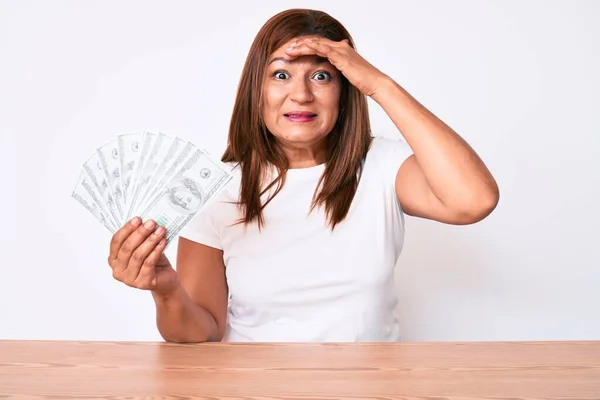 Mujer Morena Mediana Edad Sosteniendo Dólares Sentados Mesa Estresados Frustrados —  Fotos de Stock