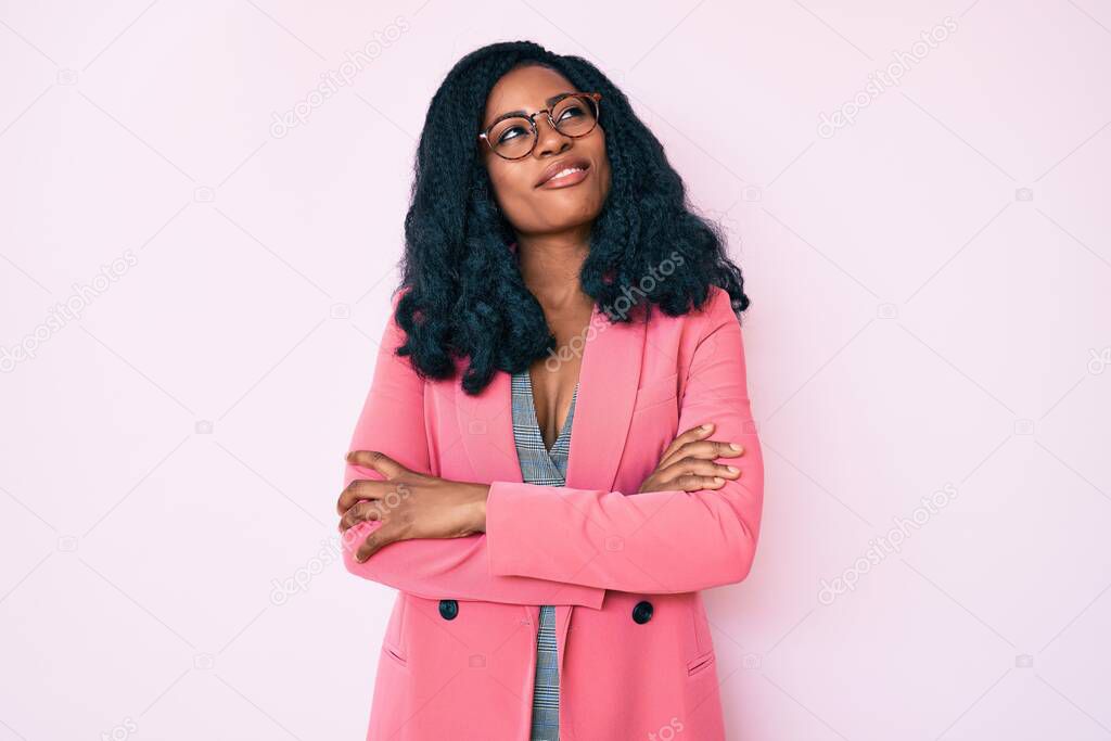 Beautiful african woman wearing business jacket and glasses smiling looking to the side and staring away thinking. 