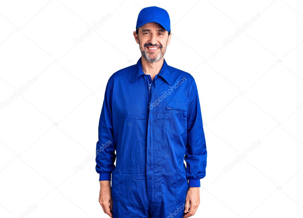 Middle age handsome man wearing mechanic uniform with a happy and cool smile on face. lucky person. 