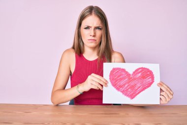 Masada kalbi olan genç sarışın kız şüpheci ve gergin görünüyor, sorun yüzünden surat asıyor. negatif kişi. 