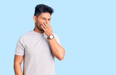 Yakışıklı Latin Amerikalı genç adam rahat bir tişört giyiyor. Kokuşmuş ve iğrenç bir koku alıyor. Dayanılmaz bir koku. Kötü kokuyor. 