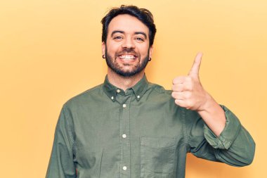 Neşeli ve pozitif gülümseyen İspanyol asıllı genç adam, mükemmel ve onay işareti yapıyor. 