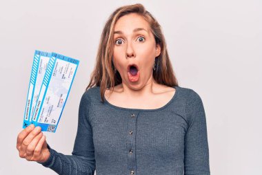 Genç, sarışın bir kadın, elinde biniş kartı tutuyor. Korkmuş ve şaşkın bir şekilde ağzı açık, şaşırmış bir halde. 